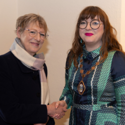 Two women standing and shaking hands