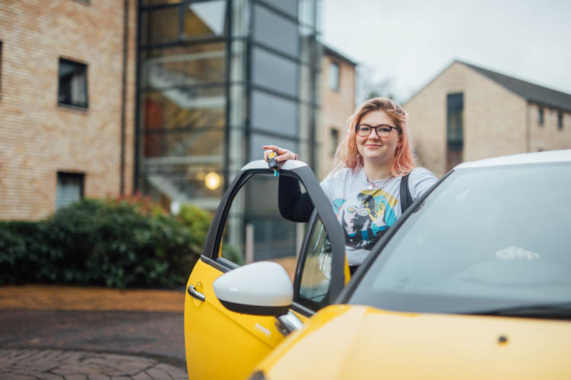 Image of Orla outside with car door open, holding car keys