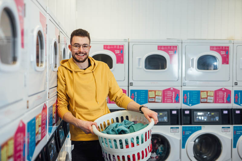 Image of Philip holding laundry basket in Elms BT9 laundry room