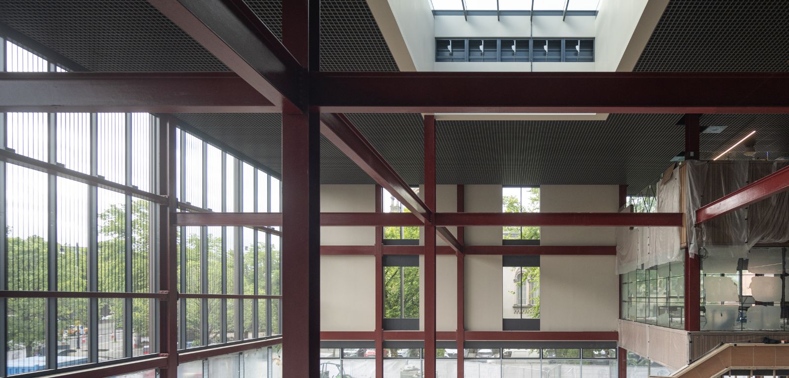 Photograph of the One Elmwood building interior under contraction showing large windows overlooking greenery and part of a staircase