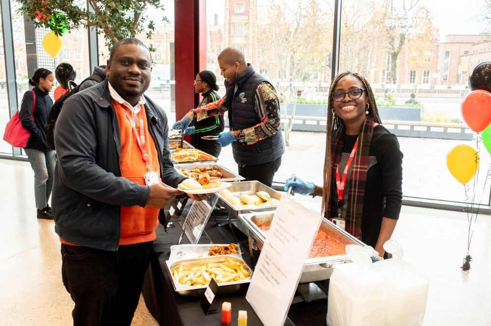 student and staff chatting at Black History Month information stand, One Elmwood