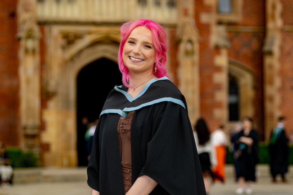 young female graduate smiling to camera