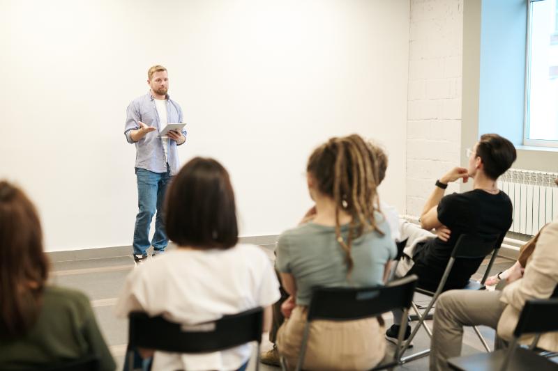 Man teaching a seminar in front of some people