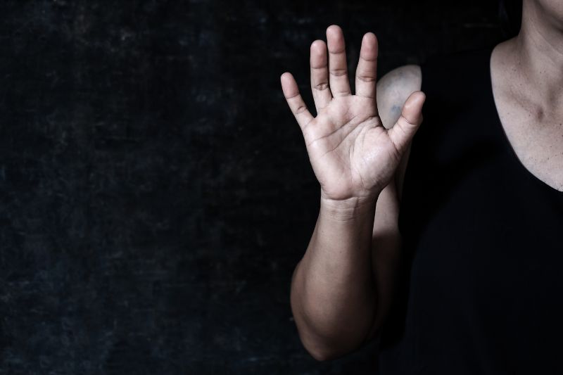 black and white photo of person holding up one arm as if signalling 'stop'