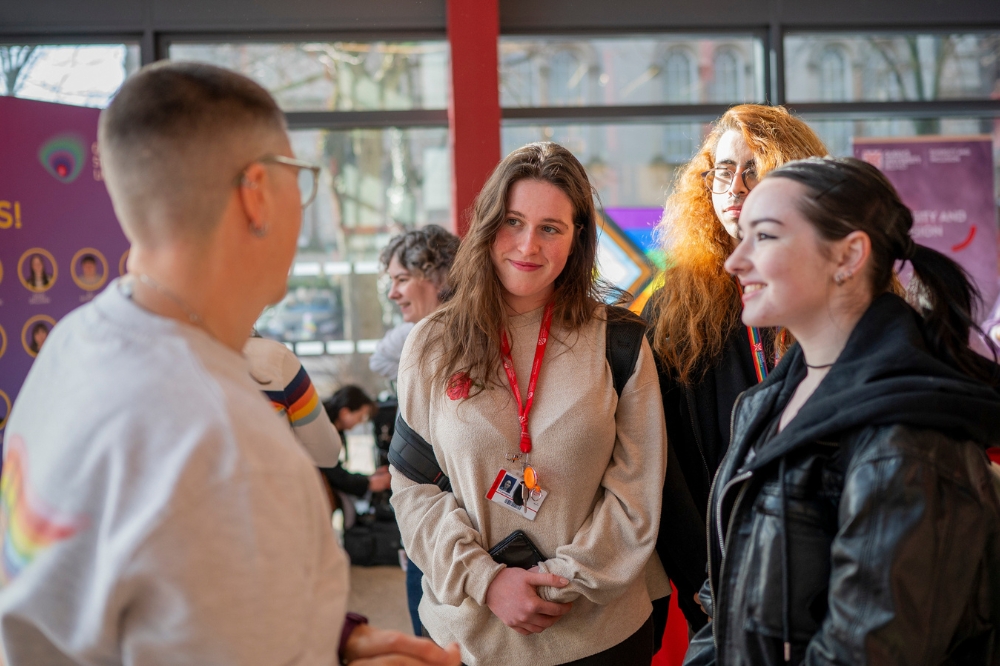 students chatting with a staff member at the LGBTQueen's Celebration Showcase, One Elmwood