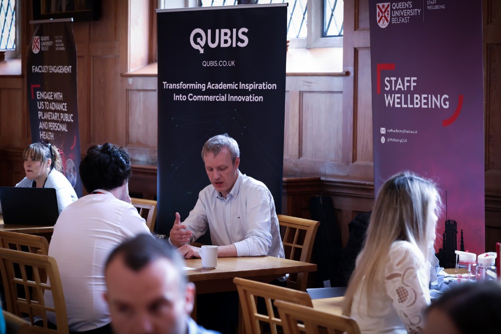 seated people chatting at information stands in an indoor event space