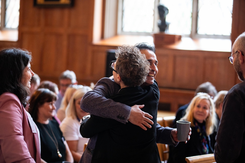attendees hugging at the Civic Mission / University of Sanctuary launch event, Queen's University Belfast, May 2024