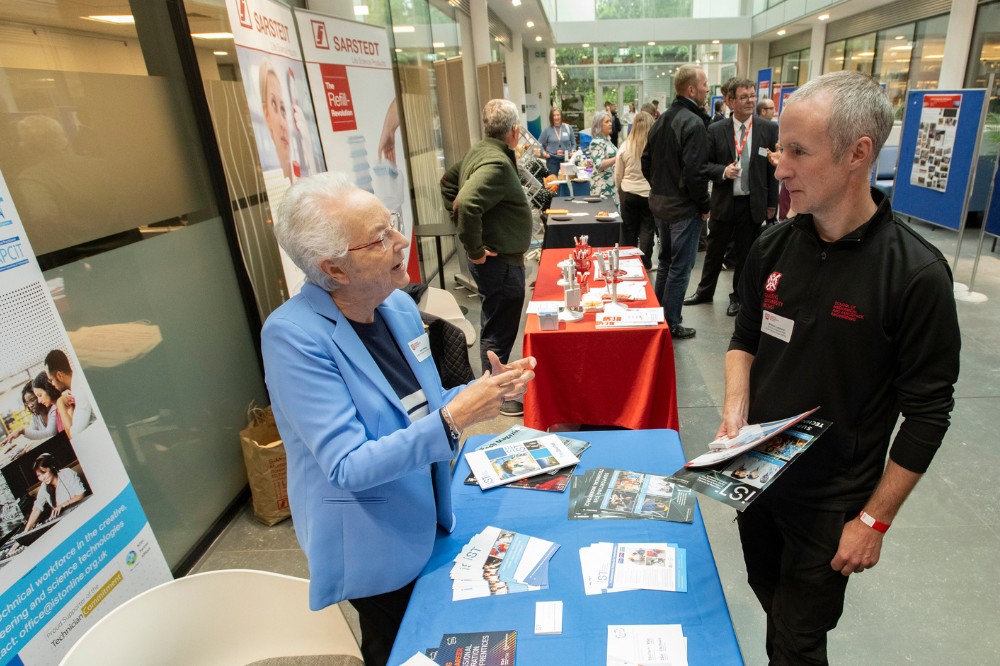 two people chatting over a table display at the Technician Showcase 2024