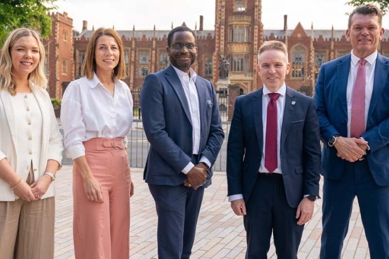 Queen's senior leaders standing outside the Lanyon Building to celebrate receiving the University of Sanctuary Status